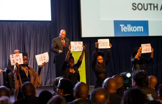 Four young women hold posters during President Jacob Zumas speech at the IEC briefing after the 2016 local government elections on August 06, 2016 in Pretoria.