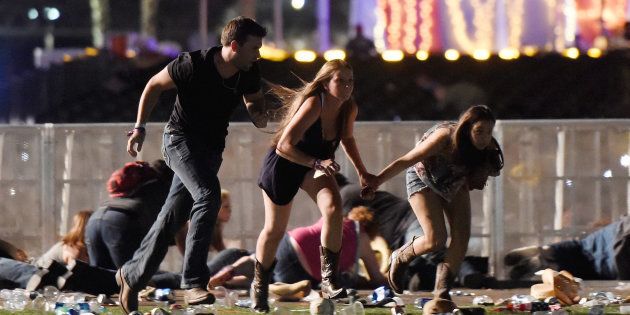 Festivalgoers run from the Route 91 Harvest country music festival in Las Vegas, Nevada, after gunfire was heard on October 1 2017.