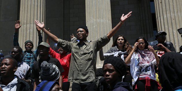Wits University stand outside the Great Hall during the #FeesMustFall protests on October 10, 2016 in Johannesburg. There were running battles between police and protestors where a bus was set alight and police used stun grenades, teargas and rubber bullets.