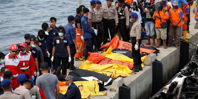 The remains of victims wait to be removed after a fire ripped through a boat carrying tourists to islands north of the capital, at Muara Angke port in Jakarta, Indonesia.