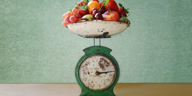 Old vintage kitchen scales laden with strawberries, oranges, pears, cherries, apples and grapes.