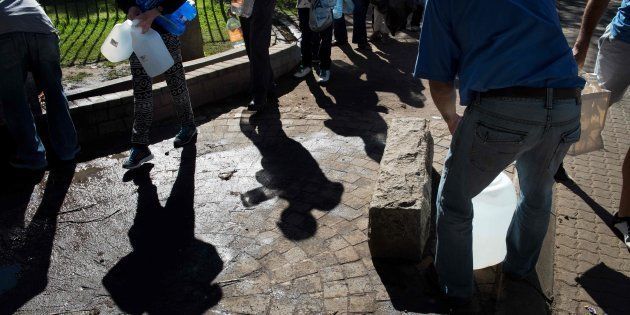 People queue up to collect drinking water from taps fed by a spring in Newlands, Cape Town, in May 2017.