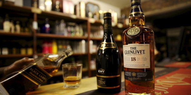 A patron pours a glass of whisky at a shebeen in Soweto, October 4, 2015.