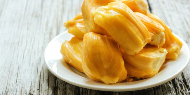 Ripe Jackfruit slices on wooden background, selective focus