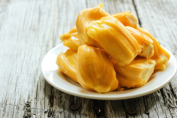 Ripe Jackfruit slices on wooden background, selective focus