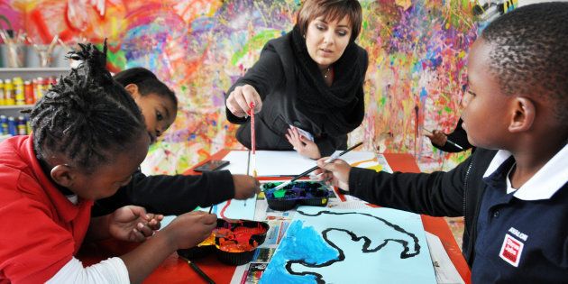 A teacher facilitates pupils during a painting session at a newly opened Steve Jobs School on June 23, 2016 in Randburg, South Africa. The schools that cater for children between 2-14 years have two campuses in South Africa. The internationally acclaimed Steve Jobs School model is based on every child having an Independent Learning Plan, centred on their own way of learning, their strengths, preferences and choices.