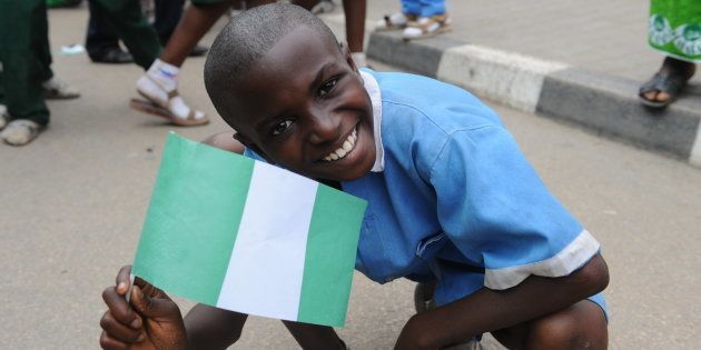 A pupil waves the national flag to welcome the Nigerian football team at the airport in Abuja in February 2013.