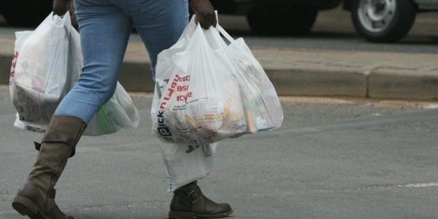 JOHANNESBURG, SOUTH AFRICA - OCTOBER 10: A shopper carries grocery bags on October 10, 2012 in Johannesburg, South Africa. With the rising cost of food, consumers have had to cut down on their purchases to save money for the more often than not 'rainy' days. (Photo by Gallo Images / Sowetan / Antonio Muchave)