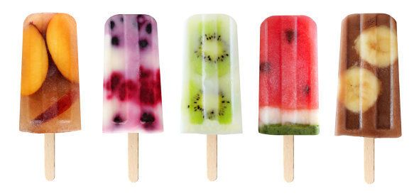 Five assorted fruit popsicles isolated on a white background