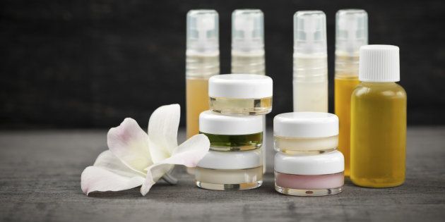 Various jars and bottles of skin care products with orchid flower.