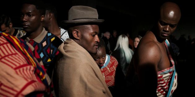 Fashion designer Laduma Ngxolo of label MaXhosa by Laduma checks his models backstage.