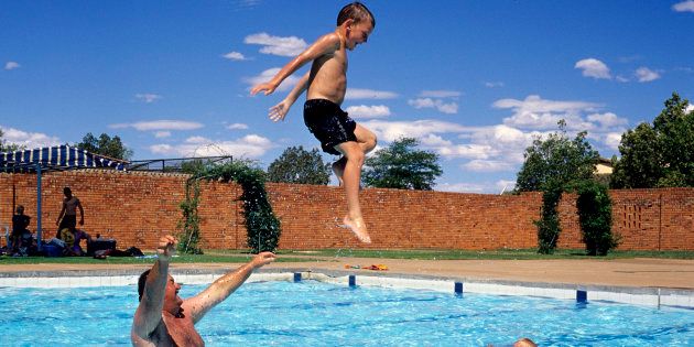 Danie Olivier and his children Dane and Louis play in a swimming pool on January 12, 2003 in Orania, in the Northern Cape province, South Africa.