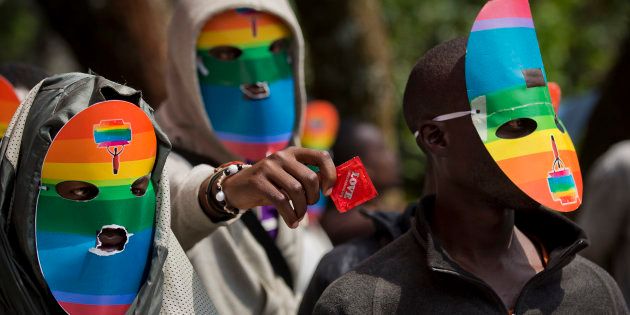 Kenyan gays and lesbians and others supporting their cause wear masks to preserve their anonymity and one holds out a condom, as they stage a rare protest, against Uganda's increasingly tough stance against homosexuality and in solidarity with their counterparts there, outside the Uganda High Commission in Nairobi, Kenya.