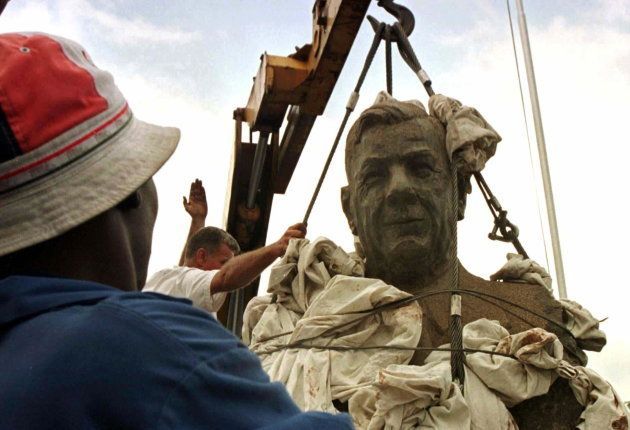 A man watches the bust of Hendrik Verwoerd being removed from the entrance of Pretoria's main hospital.