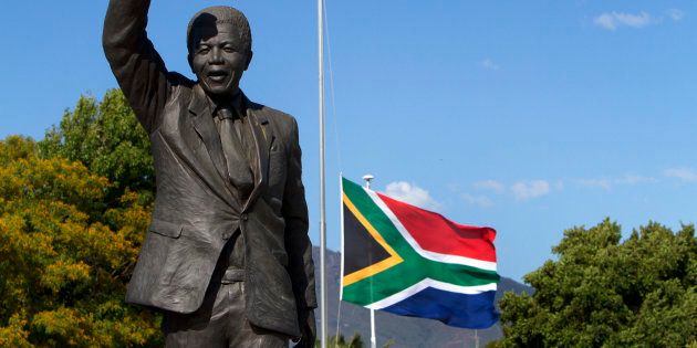 The South African flag flies at half mast behind the iconic Mandela statue at the entrance of the Groot Drakenstein Prison (formerly Victor Verster Prison) situated in the Cape Winelands outside Cape Town. December 9, 2013.