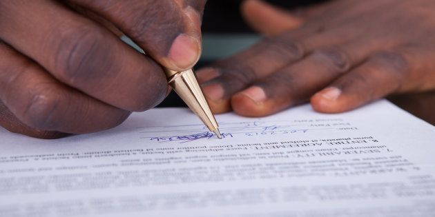 Close-up Of An African Businessperson Signing Contract