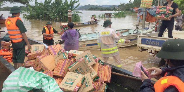 Rescuers load boats with boxes of foods, mostly instant noodles, that will be distributed to local residents in Thach Thanh district, central province of Thanh Hoa on October 12, 2017.