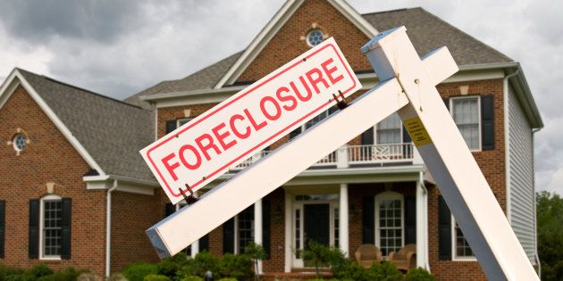 A foreclosure sign in front of a family home.