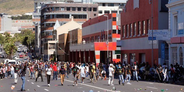 Students supporting the 'Fees Must Fall movement' face South African riot police during a protest outside the South African Parliament where South African Minster of Finance delivers his mid-term Budget address in Cape Town, on October 26, 2016.