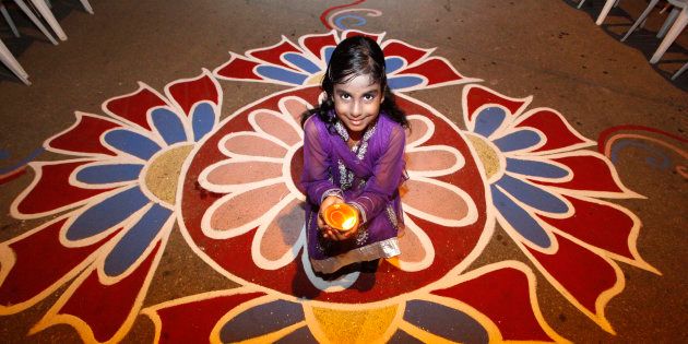 Shanaya Persad holds a diya, or oil lamp, in a street during Diwali celebrations in Felicity, central Trinidad.