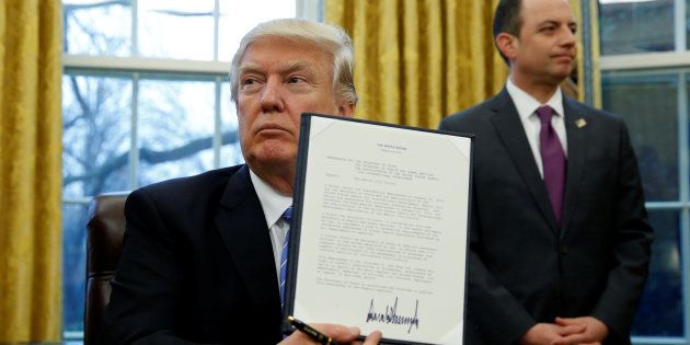 U.S. President Donald Trump holds up the executive order on the reinstatement of the Mexico City Policy after signing in the Oval Office of the White House in Washington January 23, 2017.