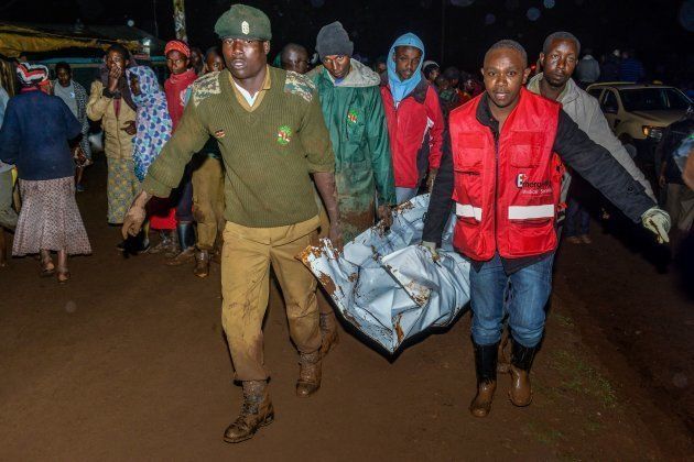 People carry a victim's body from a residential area after Patel dam burst its bank at Solai, about 40 kilometres north of Nakuru, Kenya, on May 10, 2018. (Photo by AFP) (Photo credit should read /AFP/Getty Images)