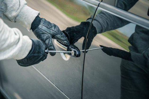 Car thief using a screwdriver to brake into a car