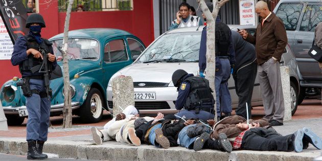 Police stand over six suspected armed robbers arrested in central Cape Town, September 3, 2009. South Africa has one of the world's highest rates of violent crime, with 18,487 murders, 36,190 rapes, and 14,201 reported carjackings in 2007-8, according to police. Many crimes go unreported. REUTERS/Mike Hutchings (SOUTH AFRICA CRIME LAW)