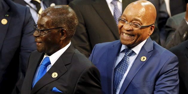 Zimbabwe President Robert Mugabe (L) reacts next to South Africa's President Jacob Zuma during the opening of the 25th African Union summit in Johannesburg, June 14, 2015.