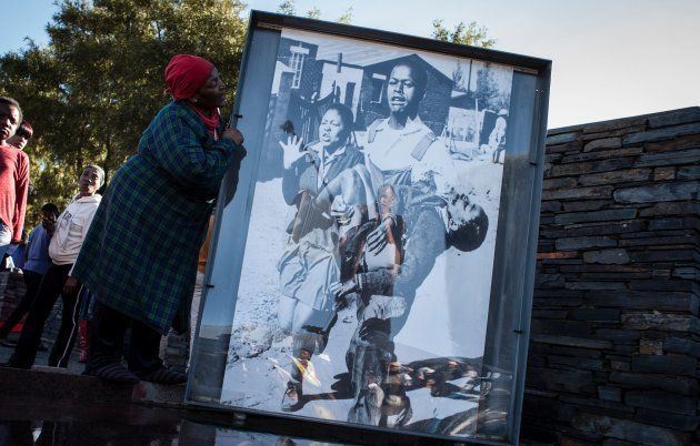 Ms Nontsikelelo Makhubu is seen next to the iconic photograph by Sam Nzima showing a dying Hector Pieterson being carried away during the Soweto Uprising in 1976, during celebrations to commemorate the 40th anniversary of the day, on June 16 2016 in Soweto. Ms Nontsikelelo Makhubu is the sister to Mr Mbuyisa Makhubu, who carried the Pieterson in the iconic photograph by Sam Nzima.