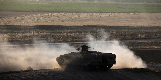 An Israeli armoured personnel carrier (APC) manoeuvres on the Israeli side of the border fence between Israel and Gaza. May 14 2018.