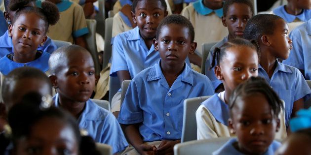 Children sit in a classroom before Prince Harry arrives for a tour of Holy Trinity Primary school during his official visit to Codrington, Barbuda, November 22, 2016.
