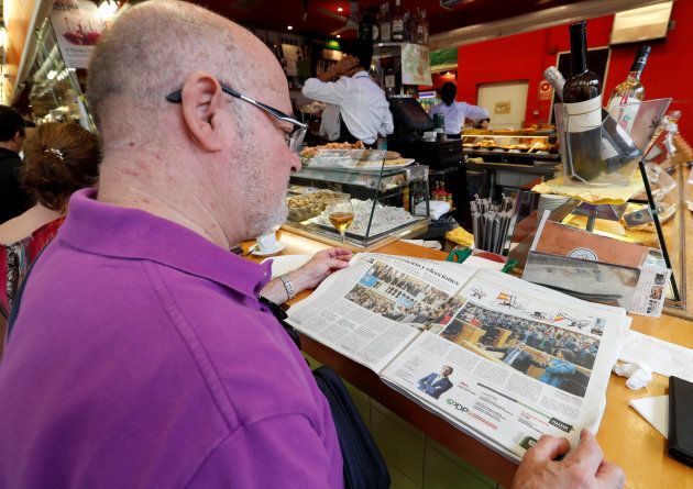A man reads a newspaper at a bar the morning after the Catalan regional parliament declared independence from Spain in Barcelona, Spain, October 28, 2017. REUTERS/Yves Herman