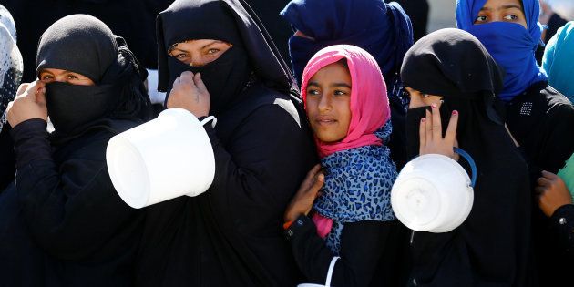 Syrian women and children line up for food distribution in the border town of Jarablus, Syria, in October.