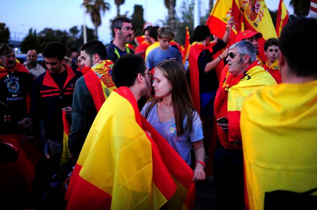 BARCELONA, SPAIN - OCTOBER 28: Two Anti-separatist supporters kiss each other during a demonstration in favor of Spanish National Police and Civil Guard through Barcelona's streets on October 28, 2017 in Barcelona, Spain. The Spanish government stripped Catalonia of its autonomy following the Catalan parliament voting yesterday to declare independence. (Photo by Borja Sanchez-Trillo/Getty Images)