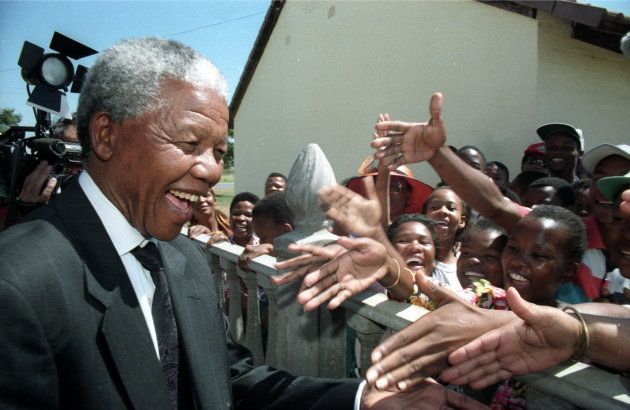African National Congress (ANC) leader Nelson Mandela greets residents of Mmabatho March 15, 1994, during a visit after the nominal homeland came under South African control following the ousting of the former President Lucas Mangope. SCANNED FROM NEGATIVE. REUTERS/Howard Burditt HB/CMC/PN