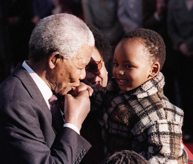 OTTAWA, CANADA: South African President Nelson Mandela kisses Lekgetho Makena, a local resident, on the hand 23 September during a welcoming ceremony at Rideau Hall in Ottawa, Canada. Mandela and his wife Graca Machel (background) are on a three-day state visit to Canada. AFP PHOTO Dave CHAN/dc (Photo credit should read DAVE CHAN/AFP/Getty Images)