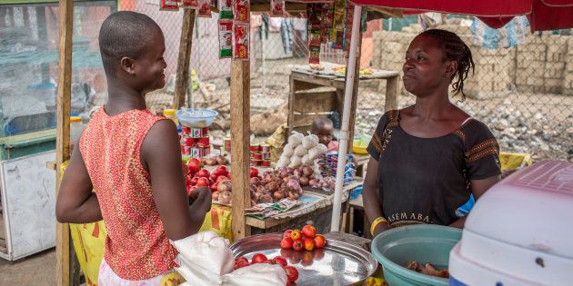 A vegetable retailer sells tomatoes to a customer at the market in Accra on September 08, 2016 in Accra, Ghana.