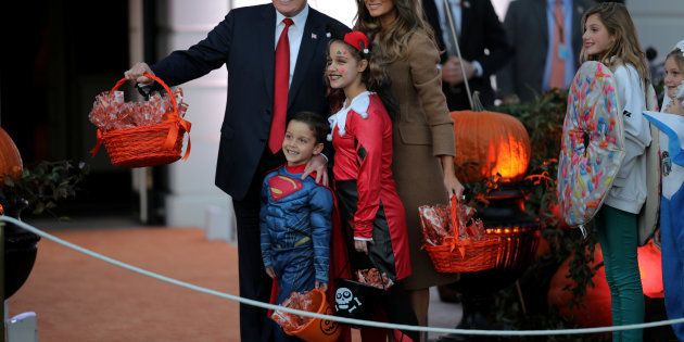 U.S. President Donald Trump and First Lady Melania Trump pose for a picture as they give out Halloween treats to children from the South Portico of the White House in Washington, U.S., October 30, 2017. REUTERS/Carlos Barria