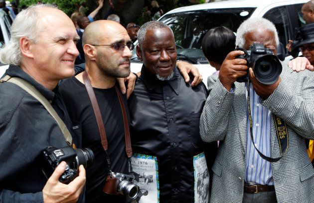 Nzima (2nd R) next to colleagues and award-winning photojournalist Peter Magubane and Jao Silva during the funeral of Alf Khumalo in Johannesburg. October 27 2012.