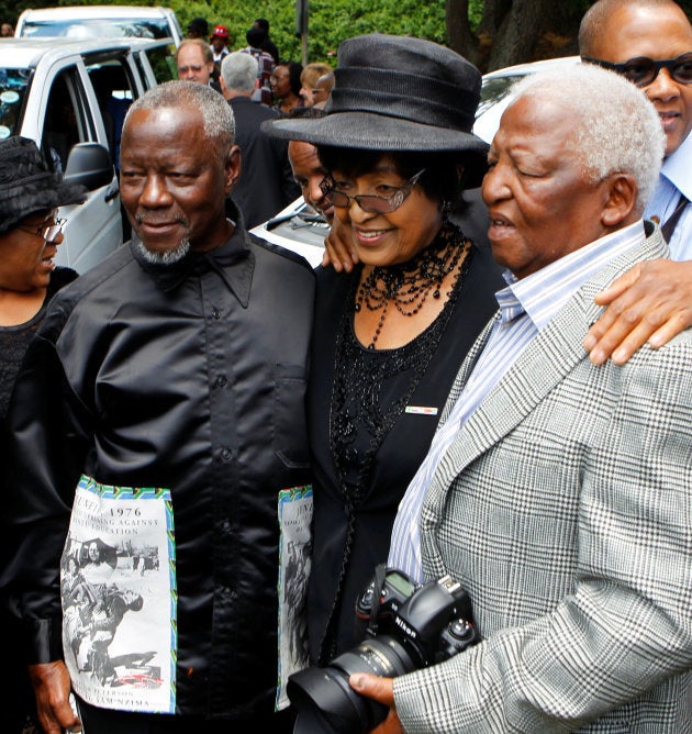 Sam Nzima (L) looks on next to colleague and award-winning photojournalist Peter Magubane (R) and the late Winnie Madikizela-Mandela during the funeral of Alf Khumalo in Johannesburg. October 27 2012.