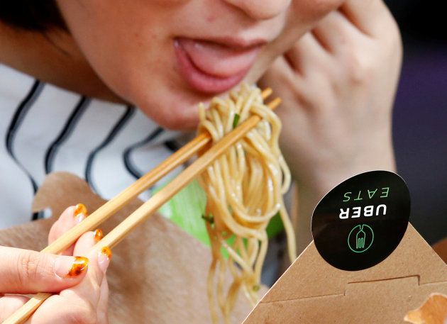 A woman eats noodles during a demonstration of a food-delivery service at the launching event of UberEats in Tokyo, Japan, September 28, 2016.