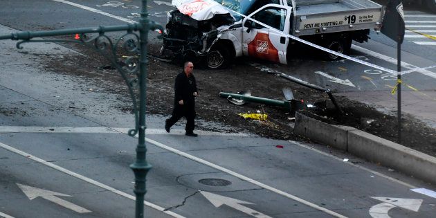 An investigator walks past a crashed pickup truck following an incident in New York on October 31, 2017. A pickup driver killed eight people in New York on Tuesday, mowing down cyclists and pedestrians, before striking a school bus in what officials branded a 'cowardly act of terror.' Eleven others were seriously injured in the broad daylight assault and first deadly terror-related attack in America's financial and entertainment capital since the September 11, 2001 Al-Qaeda hijackings brought down the Twin Towers. / AFP PHOTO / Don EMMERT (Photo credit should read DON EMMERT/AFP/Getty Images)
