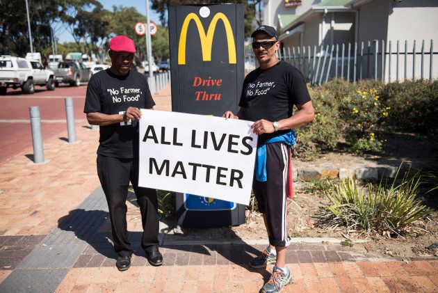 Protesters hold a banner during a demonstration by South African farmers & farm workers at the Green Point stadium to protest against farmer murders in the country, on October 30, 2017, in Cape Town.