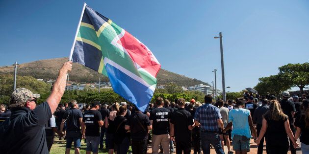A protester waves a flag during a demonstration by South African farmers & farm workers at the Green Point stadium to protest against farm murders in the country, on 30 October, 2017, in Cape Town.