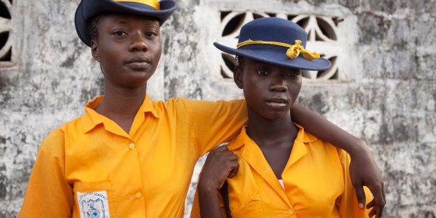 Kadidiatu Swaray, 18, (L) and her friend Mabinty Bangura, 15, arrive for class at the Every Nation Academy private school in the city of Makeni in Sierra Leone, April 20, 2012.