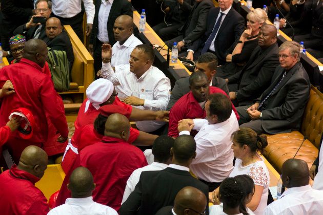 Members of Julius Malema's Economic Freedom Fighters (EFF) (in red) clash with security officials after being ordered out of the chamber during President Jacob Zuma's State of the Nation address in Cape Town, February 12, 2015. The opening of South Africa's parliament descended into chaos on Thursday as security officers fought with far-left Economic Freedom Fighters (EFF) lawmakers after they disrupted President Jacob Zuma's speech.
