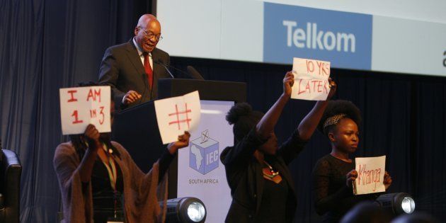 Four young women hold posters during President Jacob Zumas speech at the IEC briefing after the 2016 local government elections on August 06, 2016 in Pretoria, South Africa.