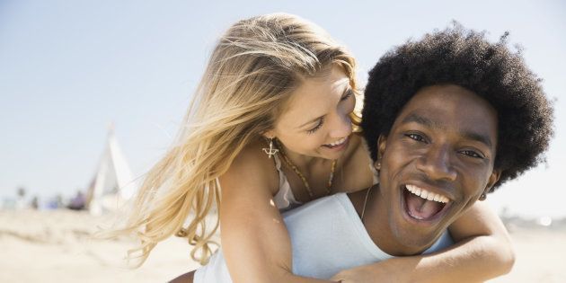 Portrait of excited man piggybacking girlfriend