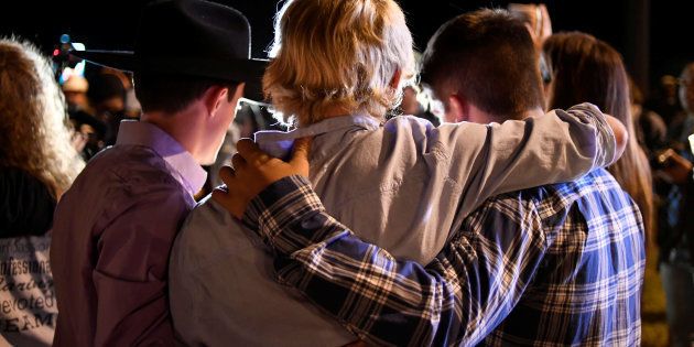 Local residents embrace during a candlelight vigil for victims of a mass shooting in a church in Sutherland Springs, Texas, U.S., November 5, 2017. REUTERS/Mohammad Khursheed